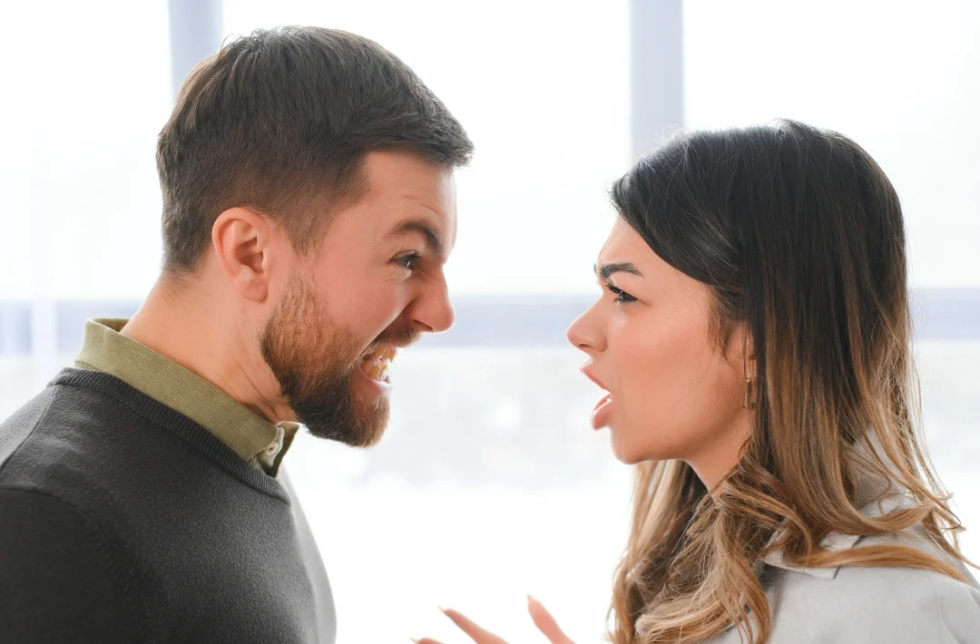 A man and woman are having a disagreement, displaying frustration and disagreement in their body language.