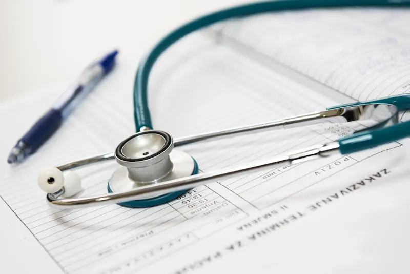 A stethoscope placed on top of a paper, representing the connection between healthcare and documentation.